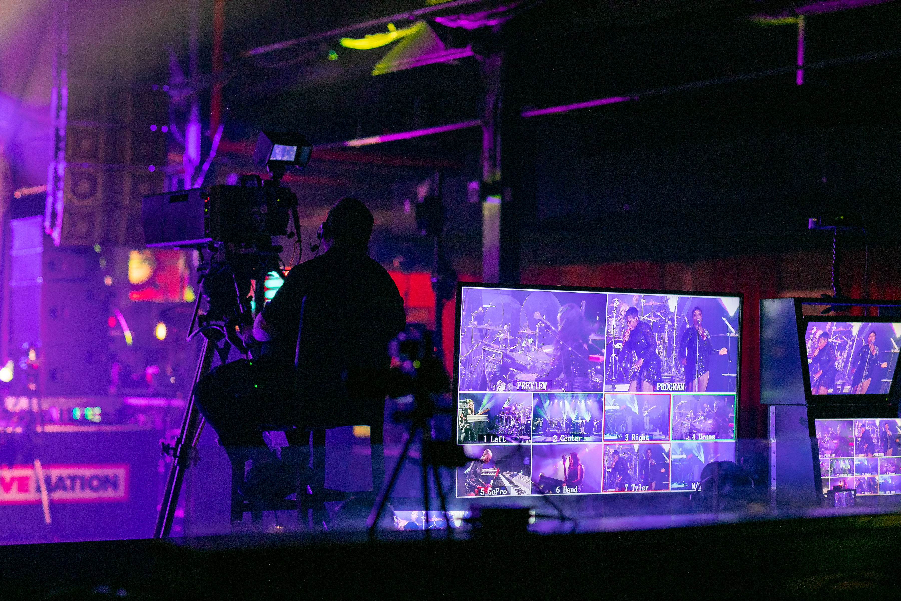Camera operator sits in a rig next to a bank of monitors displaying Fantasia’s performance at The Fillmore Charlotte