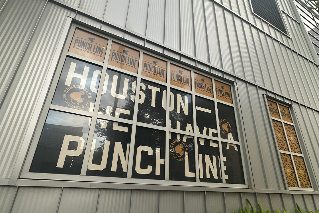 The message: Houston - We Have a Punch Line in the windown of a metallic building